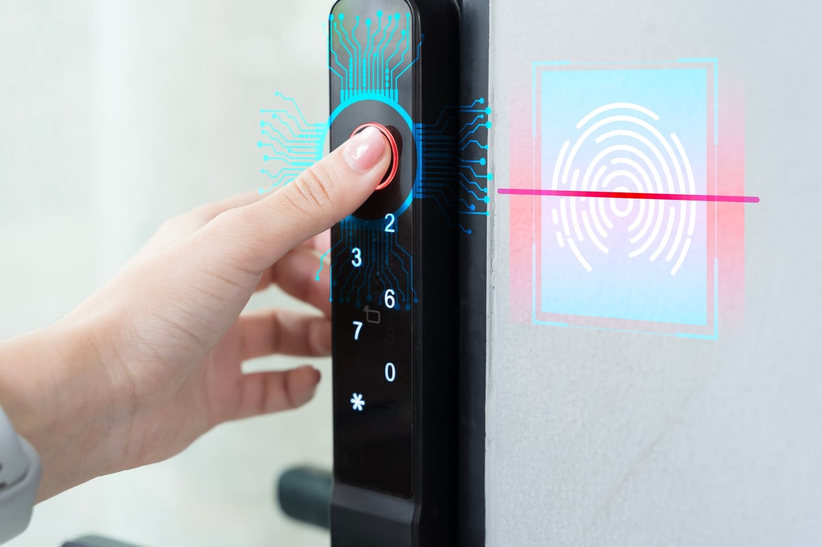 Close up hand using fingerprint scanner on smart digital door lock, showcasing biometric security, identity verification, smart home access control